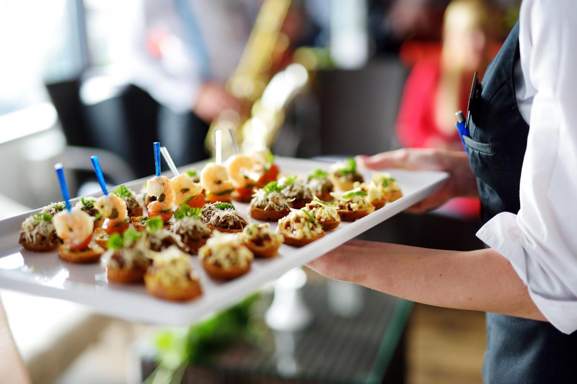 Crowne Plaza Changi Airport By Ihg Singapur Exterior foto The photo shows a tray of appetizers being held by a waiter. The tray is filled with various small bites that appear to be decorative and gourmet. Some of the appetizers feature toppings such as shrimp and what looks like a mix of herbs or spreads. T